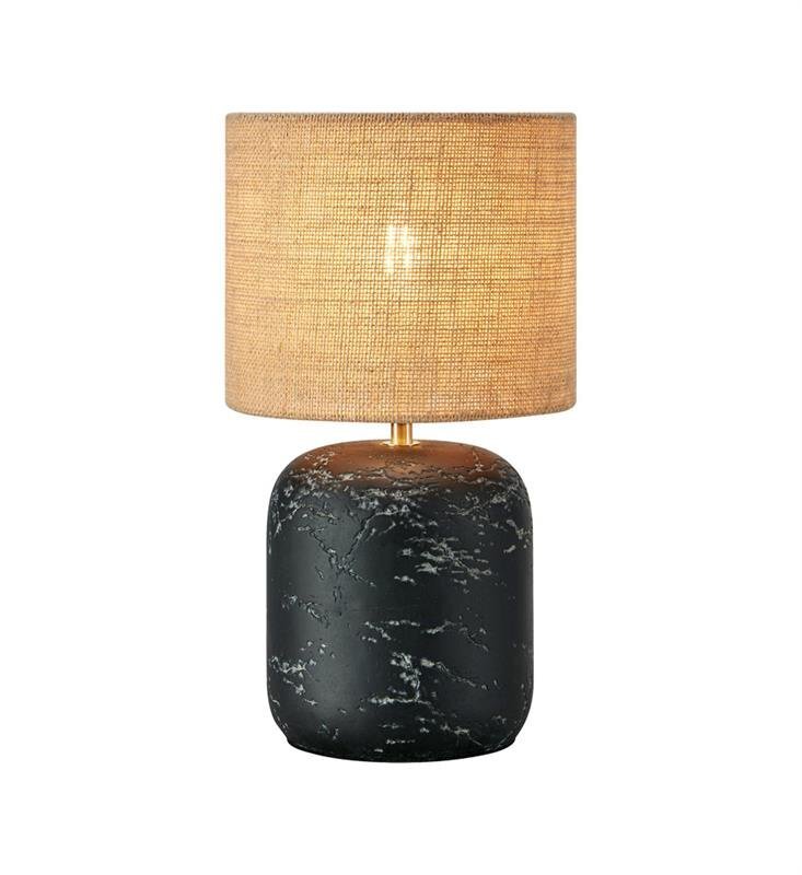Lampa stołowa z cylindrycznym abażurem w jasnym kolorze i podstawą o wyglądzie czarnego marmuru z białymi żyłkami. Elementy metalowe są w kolorze złotym.