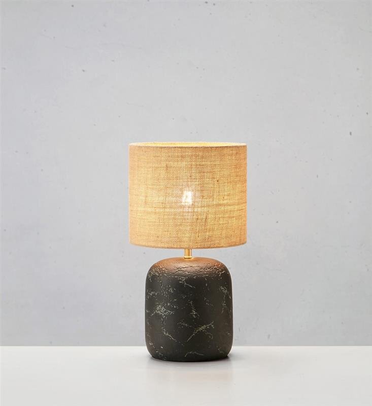 Lampa stołowa z ciemną, marmurkową podstawą i jasnym, tekstylnym abażurem, ustawiona na jasnym tle.