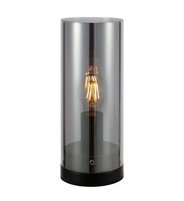 Lampa stołowa z przezroczystym cylindrycznym kloszem, wewnątrz którego znajduje się żarówka z widocznym żarnikiem, osadzona na czarnej podstawie.