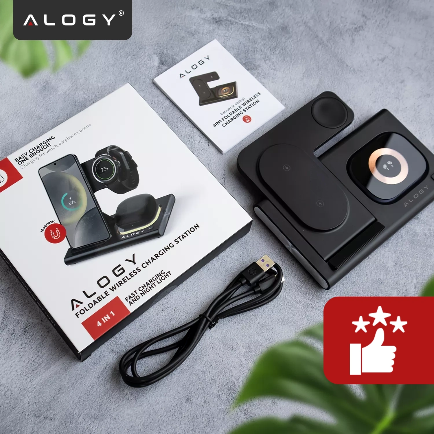 Na obrazie znajduje się czarna ładowarka indukcyjna z logo \'ALOGY\', pudełko z grafiką produktu oraz kabel USB. Obok leży instrukcja obsługi z napisem \'ALOGY 4IN1 FOLDABLE WIRELESS CHARGING STATION\'.