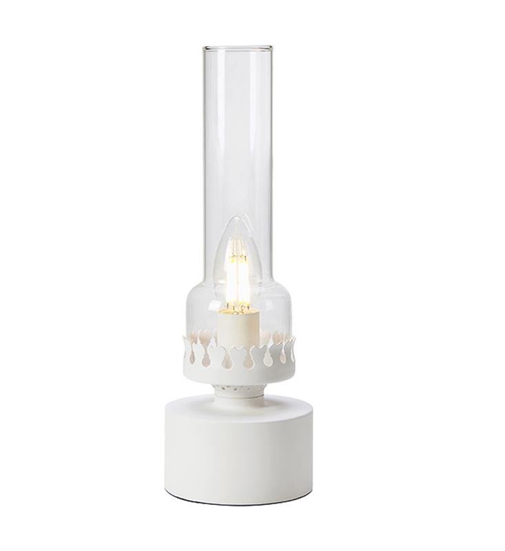 Na obrazie widoczna jest biała lampa stołowa z przezroczystym kloszem i ozdobnym wzorem wokół żarówki. Lampa ma cylindryczną podstawę i wysoką, szklaną osłonę.