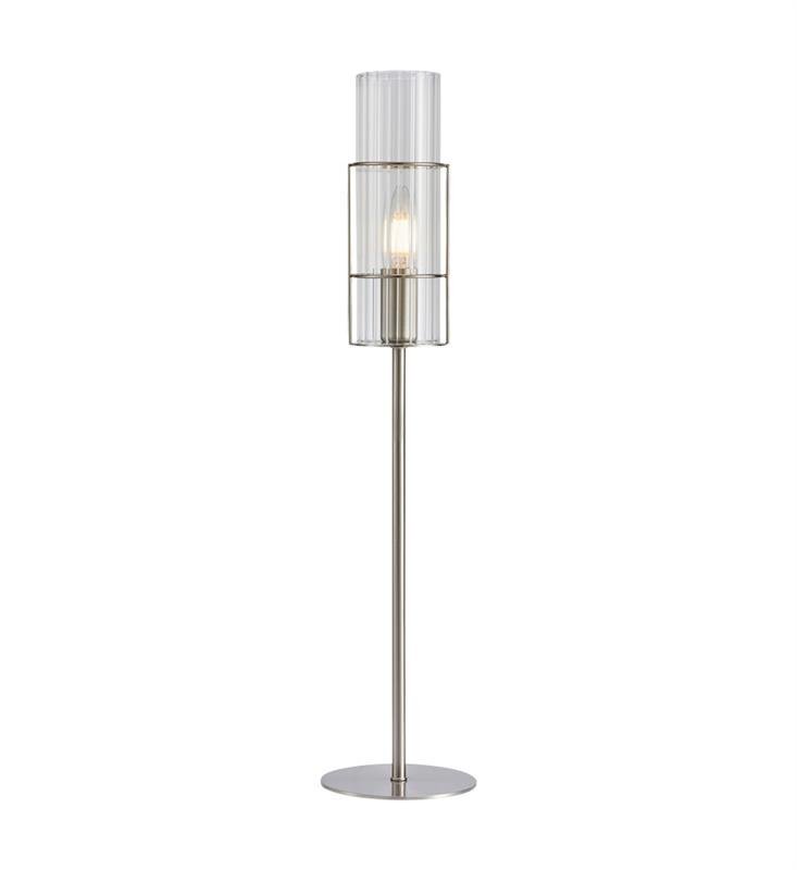 Lampa stołowa z metalową podstawą i przezroczystym kloszem, w którym widoczna jest żarówka. Konstrukcja jest smukła i elegancka.
