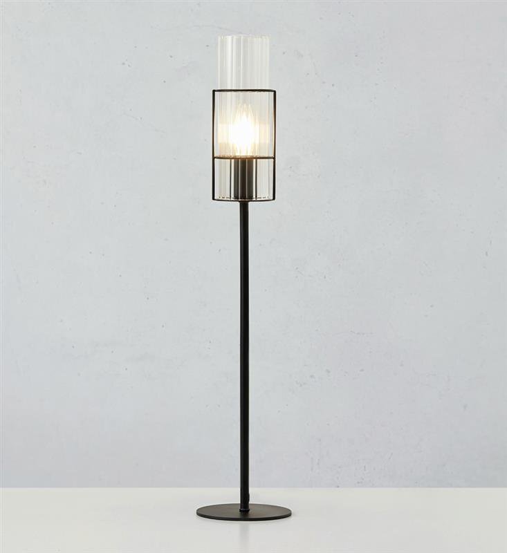 Lampa stołowa z czarną podstawą i przezroczystym kloszem, emitująca światło. Tło jest jednolite i jasne.