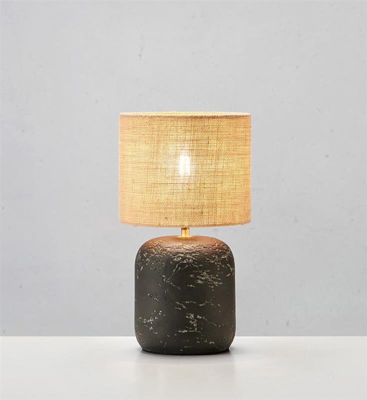Lampa stołowa z ciemną, marmurową podstawą i jasnym, tekstylnym abażurem, ustawiona na jasnym tle.