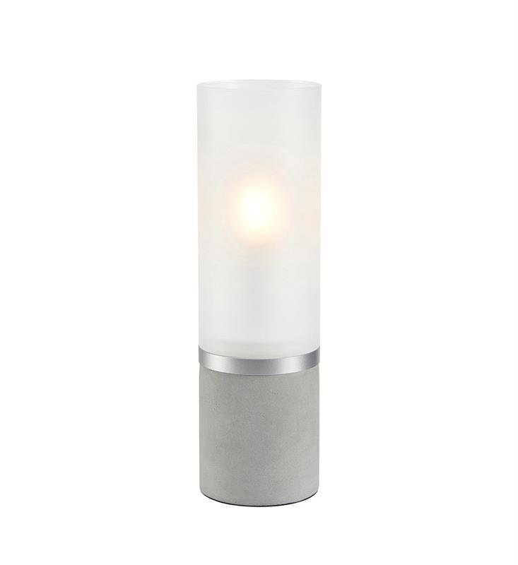 Lampa stołowa z cylindrycznym, matowym kloszem i betonową podstawą, emitująca ciepłe światło.