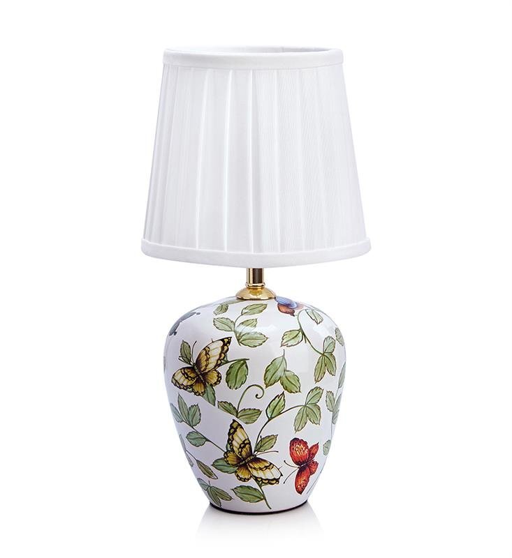 Lampa stołowa z białym, plisowanym abażurem i ceramiczną podstawą ozdobioną motywem kolorowych motyli i zielonych liści. Podstawa ma kształt zaokrąglonego wazonu.