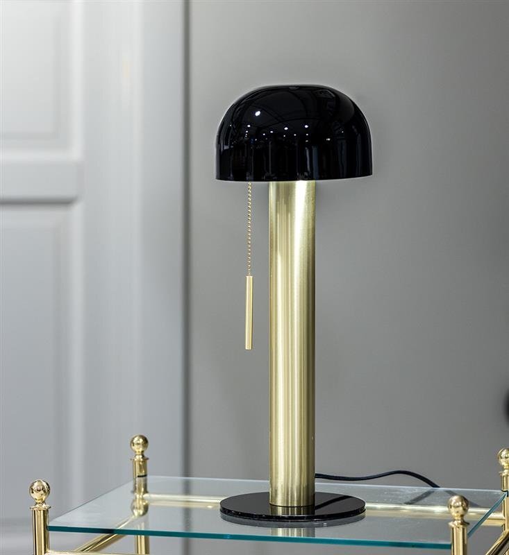 Na obrazie znajduje się elegancka lampa stołowa z czarnym kloszem i złotą podstawą, umieszczona na szklanym stoliku. Lampa posiada łańcuszek do włączania.