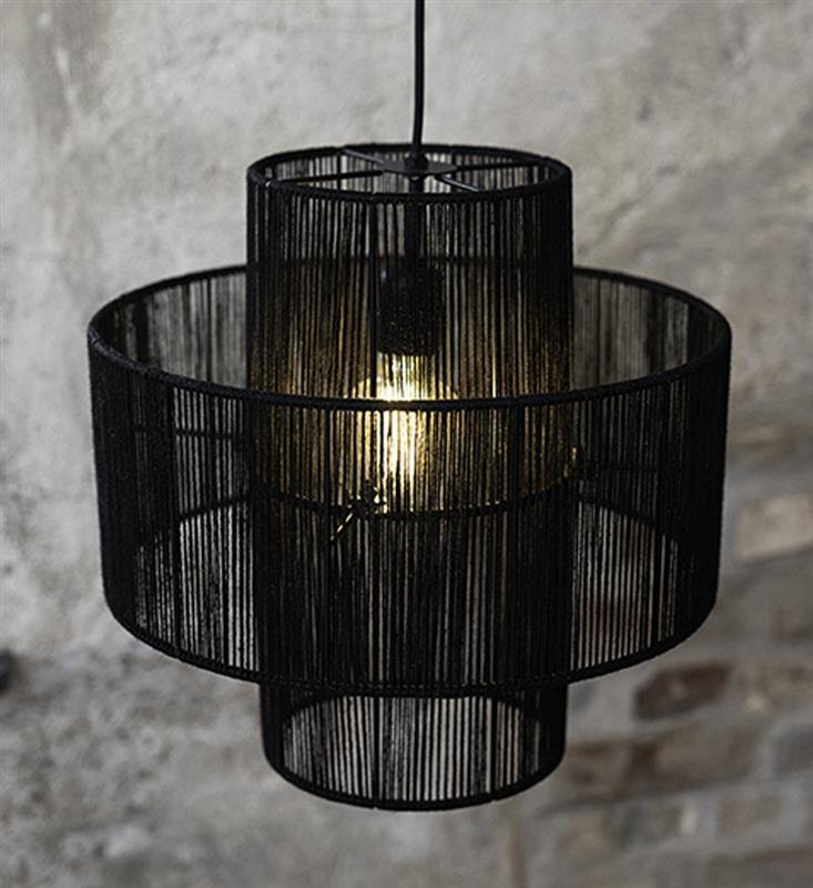 Czarna lampa wisząca z widoczną żarówką, zawieszona na tle szarej, betonowej ściany.