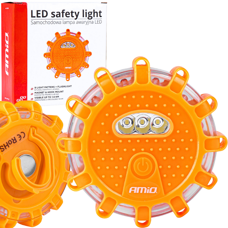 Na zdjęciu znajduje się pomarańczowa flara awaryjna LED z napisem \'AMiO\' oraz opakowanie z tekstem \'LED safety light Samochodowa lampa awaryjna LED\'.