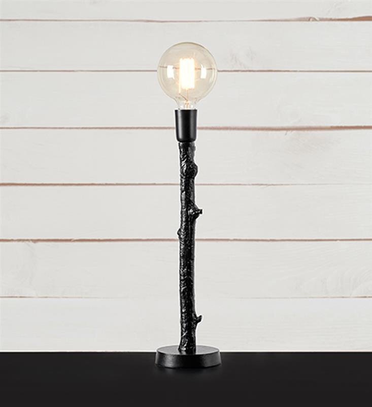 Lampa stołowa z czarną podstawą przypominającą gałąź i przezroczystą żarówką na tle jasnych, drewnianych paneli.