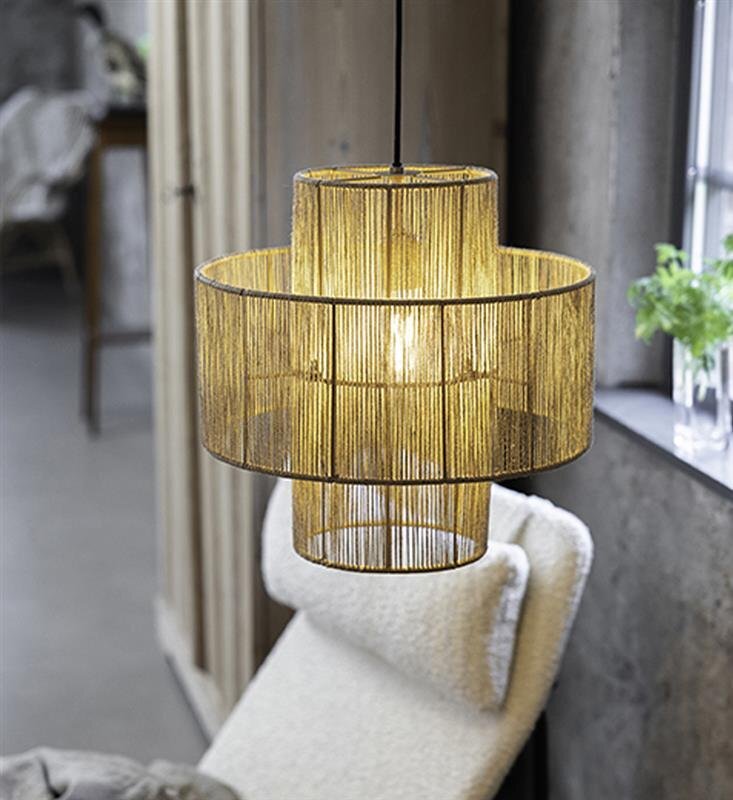 Lampa wisząca złożona z dwóch cylindrycznych abażurów wykonanych z cienkich, złotych prętów, zawieszona w jasnym, nowoczesnym wnętrzu.