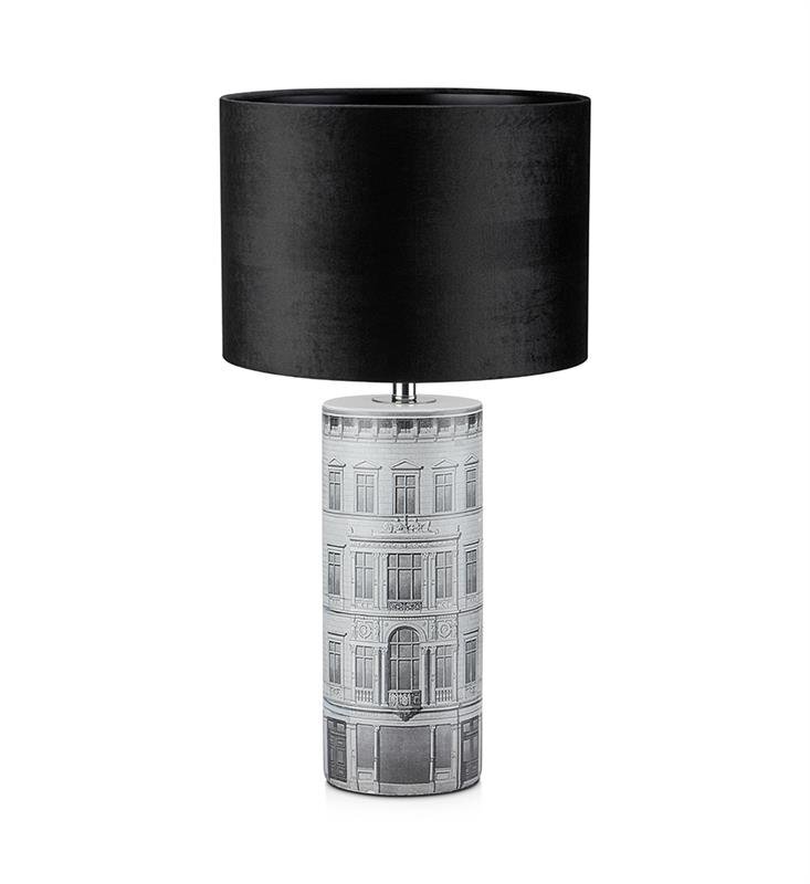 Lampa stołowa z czarnym abażurem i podstawą ozdobioną rysunkiem budynku na białym tle.