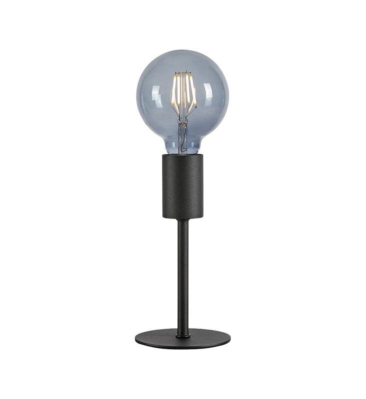 Lampa stołowa z okrągłą żarówką na czarnym, metalowym stojaku, umieszczona na białym tle.