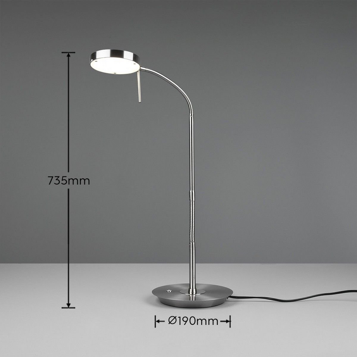 Na obrazie widoczna jest nowoczesna lampa biurkowa o metalicznym wykończeniu z okrągłą podstawą i regulowanym ramieniem. Obok lampy znajdują się wymiary: wysokość 735mm i średnica podstawy 190mm.