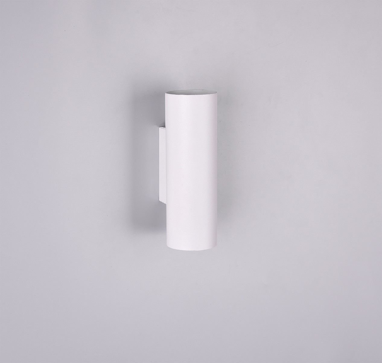 Biała, cylindryczna lampa ścienna zamontowana na jasnym tle.