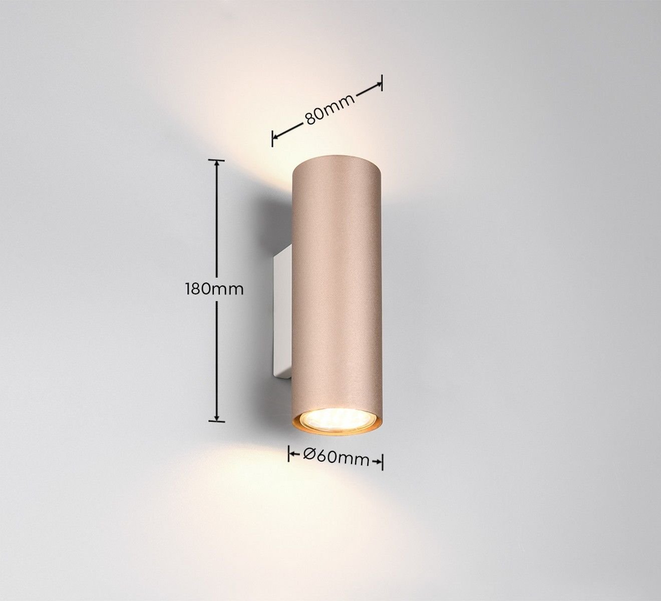 Lampa ścienna w kształcie walca z metalu, emitująca światło w górę i w dół, z wymiarami 180mm wysokości, 80mm głębokości i 60mm średnicy. Tło jest jednolite i neutralne.