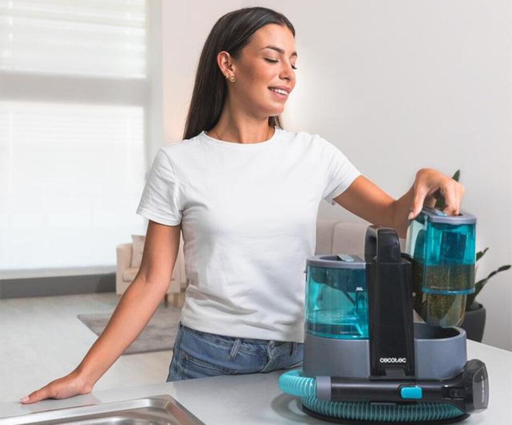 Osoba trzyma pojemnik od odkurzacza piorącego CECOTEC Conga 4000 Carpet. Na urządzeniu widoczne jest logo \'CECOTEC\'.