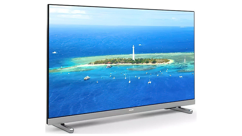 Telewizor z cienką ramką wyświetla obraz wyspy otoczonej błękitnym oceanem. Na ekranie widoczna jest latarnia morska i kilka łodzi na wodzie.