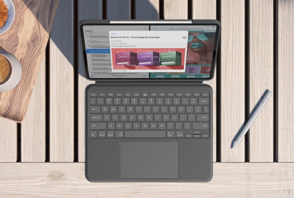Na drewnianym stole znajduje się otwarty iPad w etui z klawiaturą, obok leży rysik. Na ekranie widoczne są aplikacje z tekstem i grafiką dotyczącą projektowania opakowań.