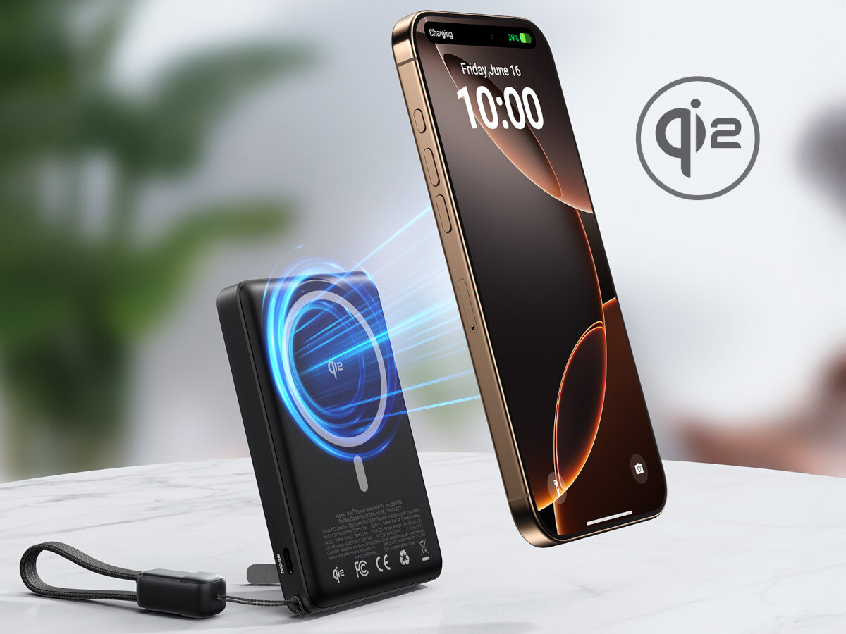 Na obrazie widać czarny powerbank z oznaczeniem \'qi2\' oraz smartfon unoszący się nad nim z wyświetlaczem pokazującym datę i godzinę: piątek, 16 czerwca, 10:00. W tle znajduje się rozmyte wnętrze z rośliną.
