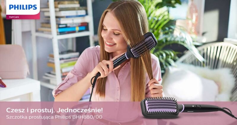 Osoba używa szczotki prostującej do włosów w jasnym pomieszczeniu. Na dole obrazu widnieje tekst: \'Czesz i prostuj. Jednocześnie! Szczotka prostująca Philips BHH880/00\'.