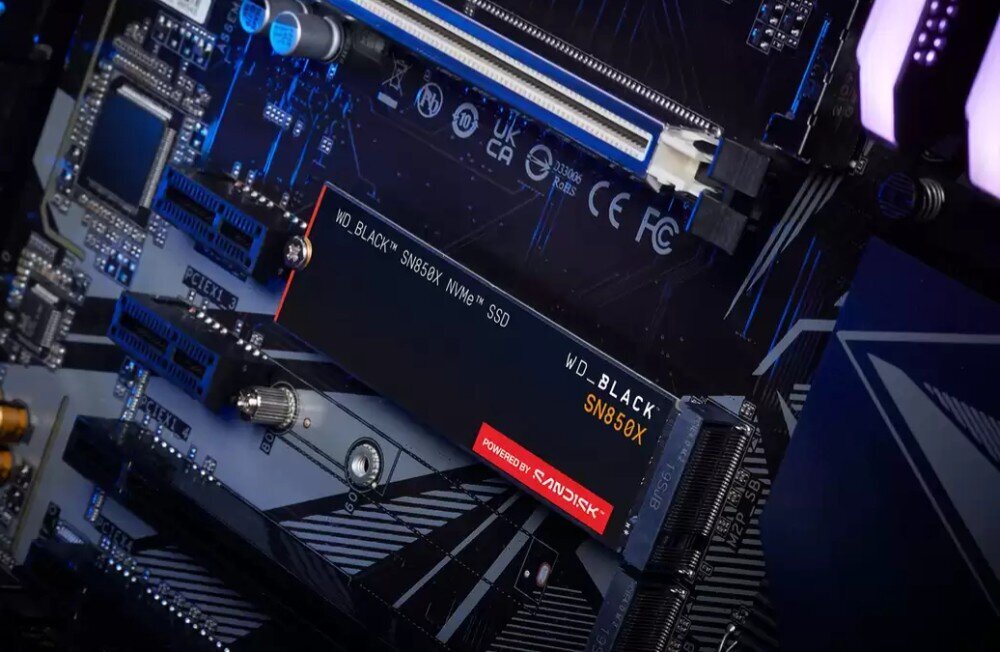 Na obrazie widoczny jest dysk SSD WD_BLACK SN850X NVMe zamontowany na płycie głównej. Na dysku znajduje się napis \'POWERED BY SANDISK\'.