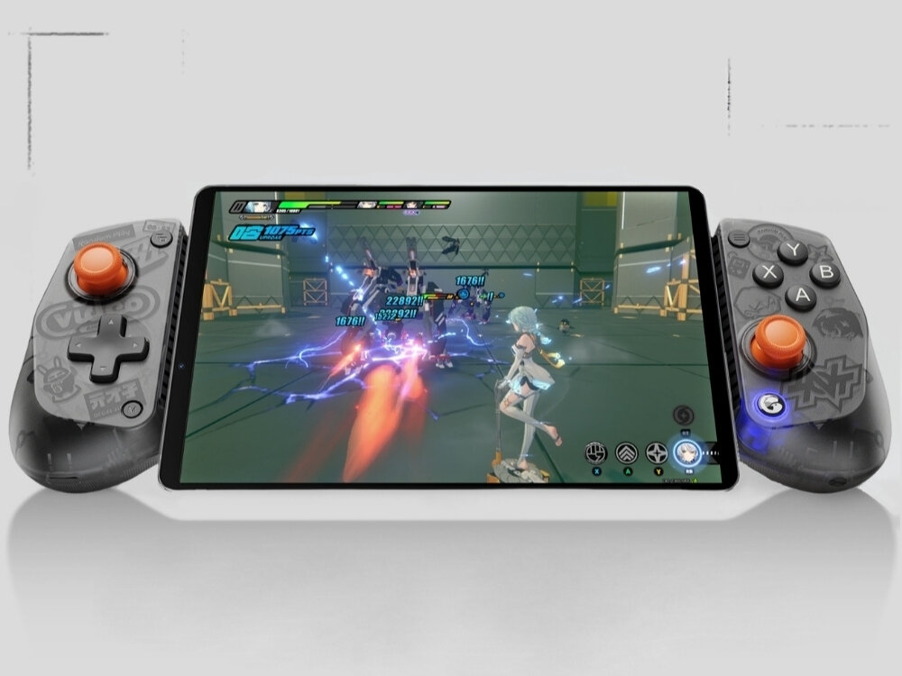 Na obrazie widoczny jest tablet z grą wideo, do którego po obu stronach podłączone są czarne kontrolery z pomarańczowymi joystickami. Na ekranie gry widać postać i efekty świetlne związane z akcją.