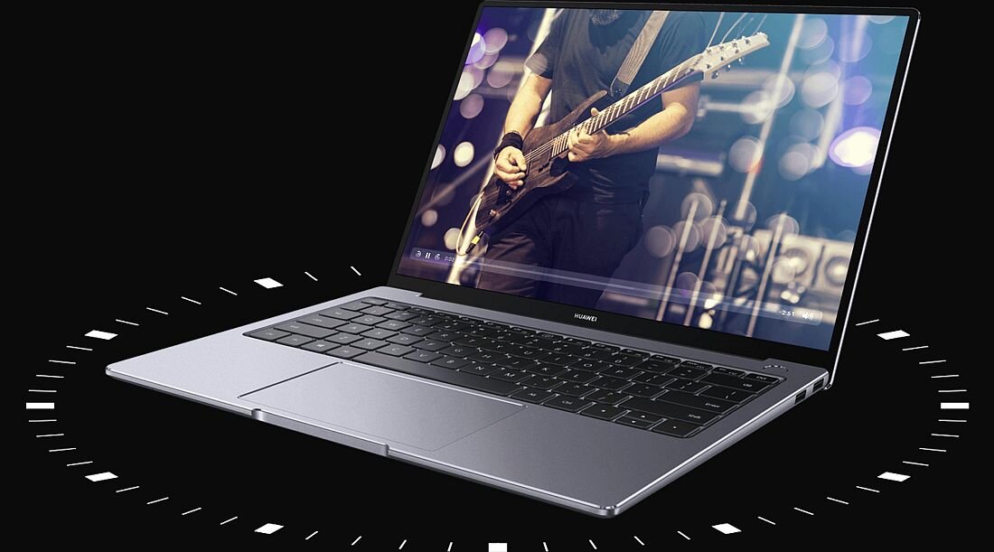 Laptop z otwartym ekranem, na którym wyświetlany jest obraz muzyka grającego na gitarze. Na obudowie widoczne jest logo \'HUAWEI\'.