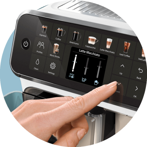 Panel dotykowy ekspresu do kawy z ikonami różnych napojów, takich jak Espresso, Coffee, Cappuccino, Latte Macchiato i Iced Coffee. Palec wskazuje na ikonę Latte Macchiato, a na ekranie widoczne są suwaki do regulacji mocy i ilości kawy oraz mleka.