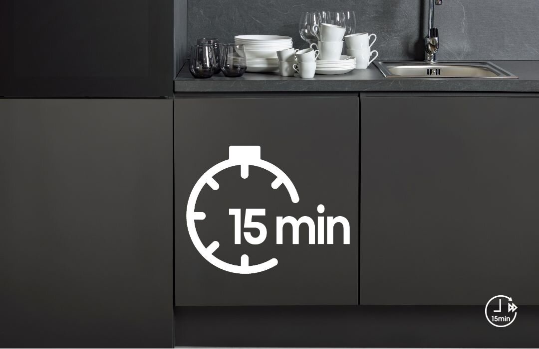 Kuchnia z ciemnymi szafkami, na blacie stoją białe filiżanki i szklanki. Na drzwiach szafki widoczny jest symbol zegara z napisem \'15 min\'.