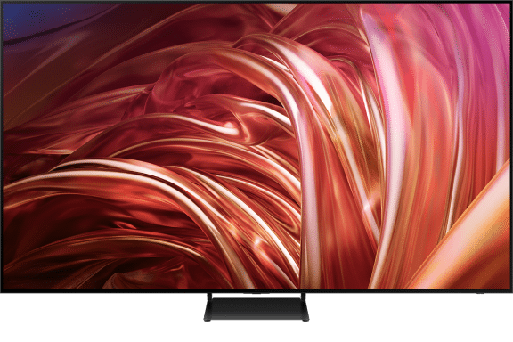 Telewizor z dużym ekranem wyświetlający abstrakcyjny wzór w odcieniach czerwieni i pomarańczu. Urządzenie stoi na prostokątnej podstawie.
