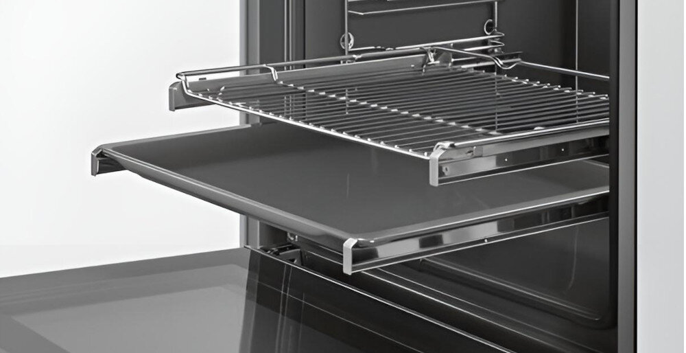 Wnętrze piekarnika z widoczną metalową kratką i wysuwaną blachą. Piekarnik ma nowoczesny design z elementami ze stali nierdzewnej.