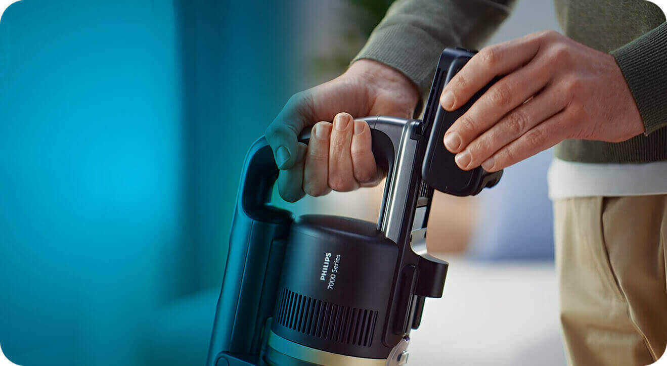 Osoba trzyma odkurzacz z widocznym napisem \'PHILIPS 7000 Series\'.