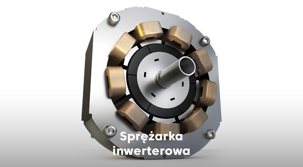 Obraz przedstawia sprężarkę inwerterową z widocznymi elementami metalowymi i miedzianymi. Na dole znajduje się tekst: \'Sprężarka inwerterowa\'.