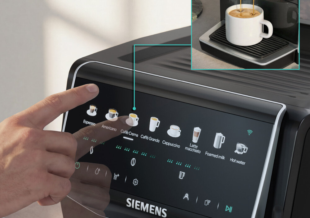 Osoba dotyka panelu dotykowego ekspresu do kawy z widocznymi ikonami napojów: Espresso, Americano, Café Crema, Caffè Grande, Cappuccino, Latte macchiato, Foamed milk, Hot water. Na ekranie widoczne jest logo \'SIEMENS\'.