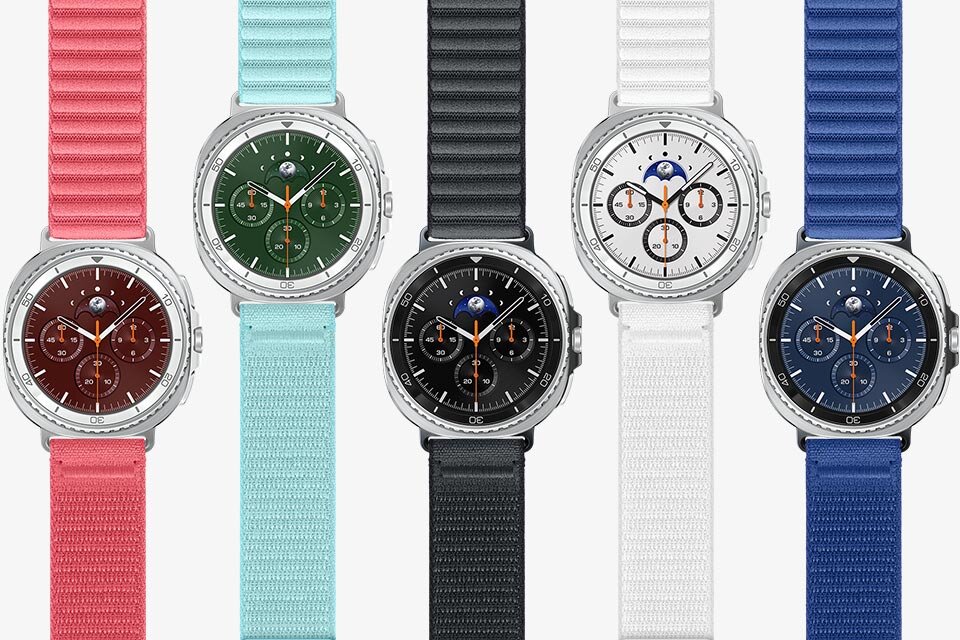Pięć smartwatchy z okrągłymi tarczami, każdy z innym kolorem paska: różowy, miętowy, biały, czarny i niebieski. Tarcze zegarków mają różne kolory i widoczne są na nich trzy małe tarcze oraz wskaźnik faz księżyca.