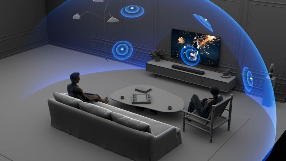 W salonie znajduje się telewizor z wyświetlanym obrazem eksplozji oraz soundbar umieszczony na szafce. Dwie osoby siedzą na kanapie i fotelu, a wokół nich widoczna jest wizualizacja dźwięku przestrzennego w postaci niebieskich fal.