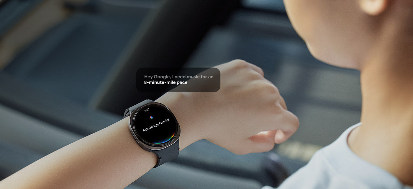 Kobieta nosząca Galaxy Watch8 podnosi rękę i spogląda na zegarek. Na ekranie widoczny jest napis „Zapytaj Google Gemini” wraz z ikoną Gemini. Obok pojawia się okienko z komunikatem: „Hej, Google, potrzebuję muzyki do tempa 8 minut na półtora kilometra.” Na dole ekranu pojawia się logo „Google Gemini”.