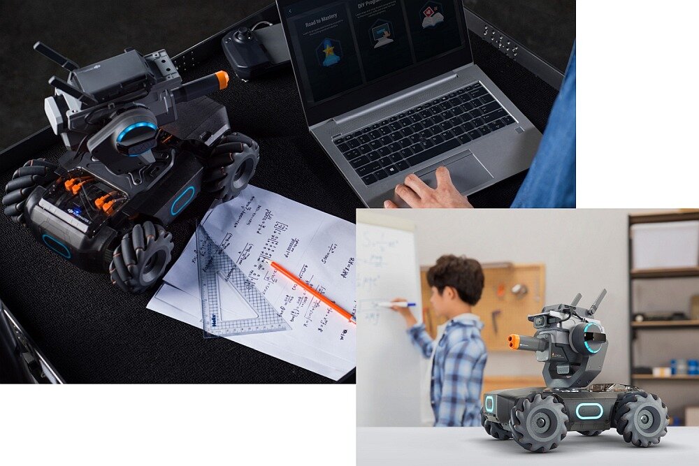 Na obrazie widać robota z czterema kołami i elementami w kolorze niebieskim oraz pomarańczowym, stojącego obok laptopa i notatek z rysunkami geometrycznymi. W tle znajduje się osoba pisząca na tablicy, a obok robota leży pomarańczowy ołówek.
