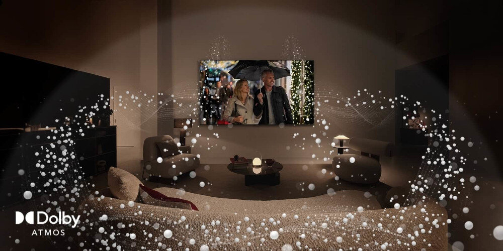 W salonie na ścianie wisi telewizor, na którym wyświetlana jest scena z filmu przedstawiająca parę pod parasolem. W lewym dolnym rogu widoczne jest logo \'Dolby Atmos\', a wokół pokoju rozprzestrzeniają się wizualizacje dźwięku.