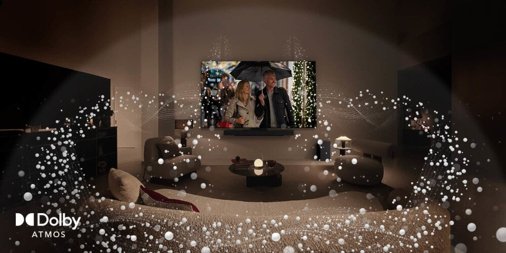 W salonie znajduje się telewizor wyświetlający scenę z filmu, a wokół niego widoczne są efekty dźwiękowe Dolby Atmos. W lewym dolnym rogu znajduje się logo \'Dolby Atmos\'.