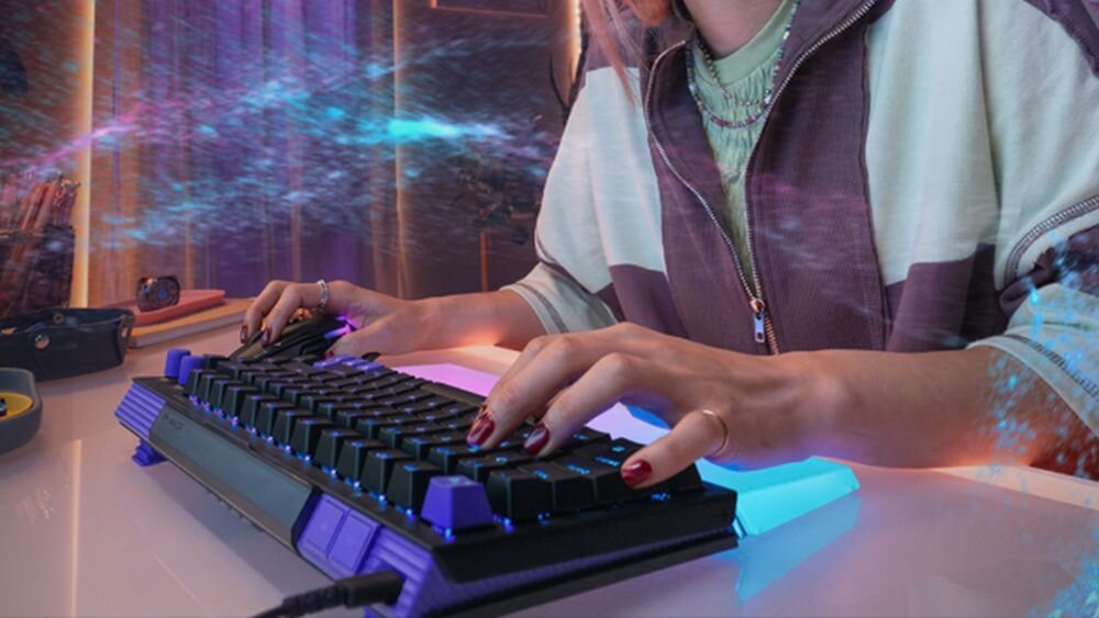Klawiatura LOGITECH G512 X 75 Częstotliwość raportowania 8000 Hz 8000 razy na sekundę Logitech G512 X 75 1000 Hz 8K 0,125 ms - Osoba pisząca na podświetlanej klawiaturze przy biurku w nowoczesnym pokoju.