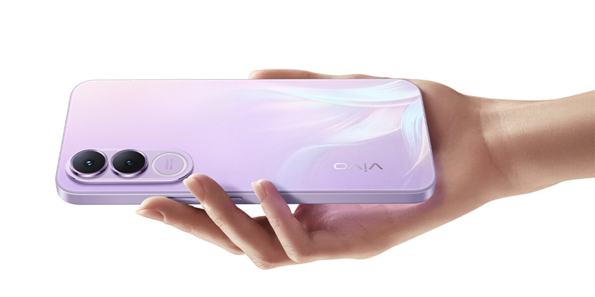Osoba trzyma w dłoni smartfon w kolorze fioletowym z dwoma dużymi obiektywami aparatu i logo \'VIVO\' na obudowie.