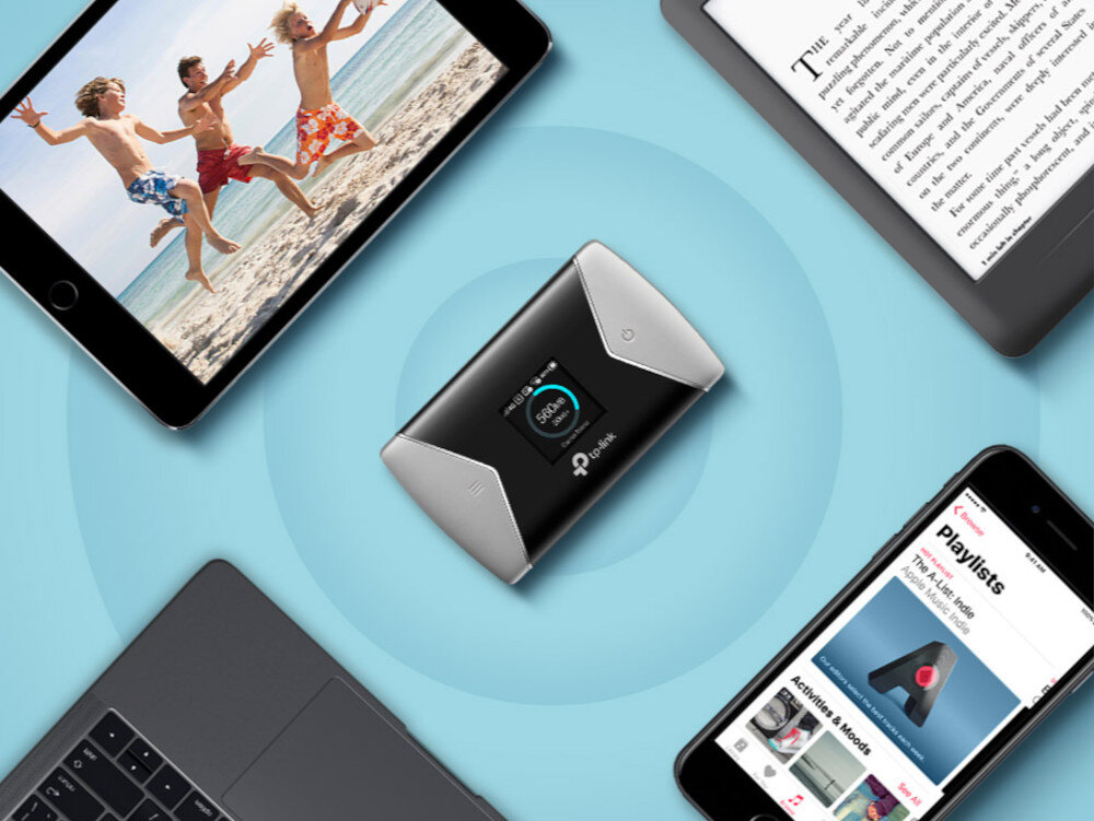 Na obrazie znajduje się czarny router TP-LINK z wyświetlaczem, otoczony przez różne urządzenia elektroniczne, takie jak tablet, laptop i smartfon. Logo TP-LINK jest widoczne na routerze.
