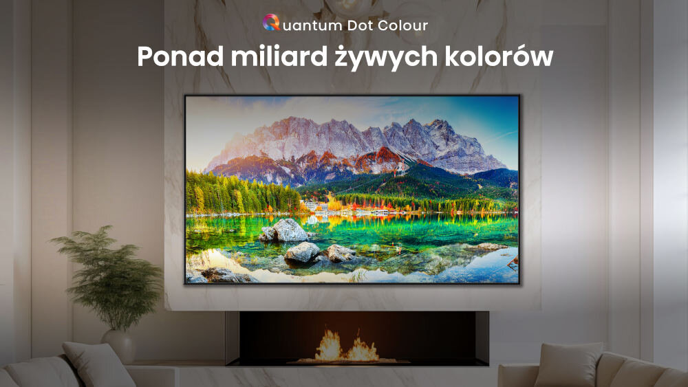 Na ścianie wisi telewizor wyświetlający krajobraz górski z jeziorem. Nad telewizorem widnieje napis \'Ponad miliard żywych kolorów\'.