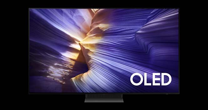 Telewizor z wyświetlaczem prezentującym kolorowy, abstrakcyjny wzór przypominający fale lub skały. Na ekranie widoczny jest napis \'OLED\'.