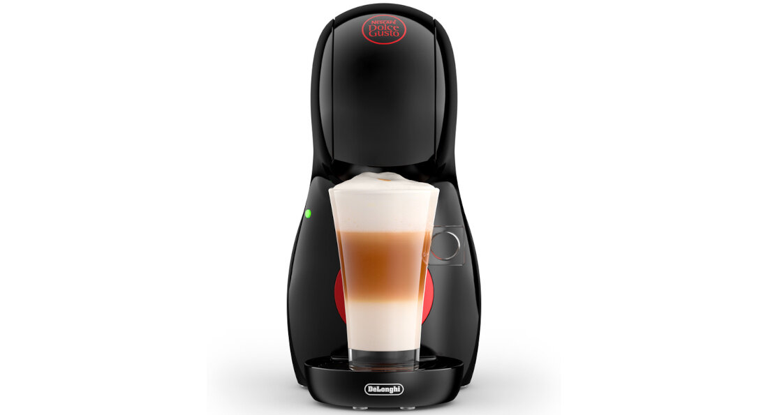Czarny ekspres do kawy z logo \'Dolce Gusto\' na górze i \'DeLonghi\' na dole, z przezroczystą szklanką wypełnioną warstwową kawą. Obok ekspresu widoczny jest zielony wskaźnik świetlny.