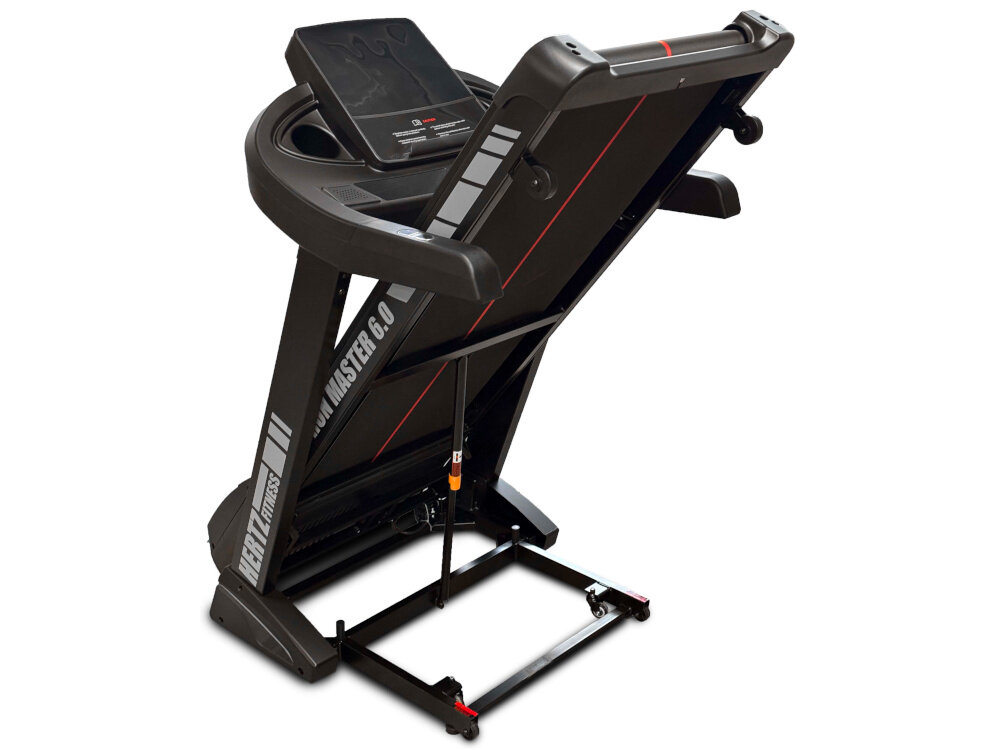 Bieżnia elektryczna w pozycji złożonej, z widocznym napisem \'HERTZ FITNESS Run Master 6.0\'. Urządzenie ma ciemną kolorystykę z czerwonymi akcentami i wyświetlaczem na panelu sterującym.