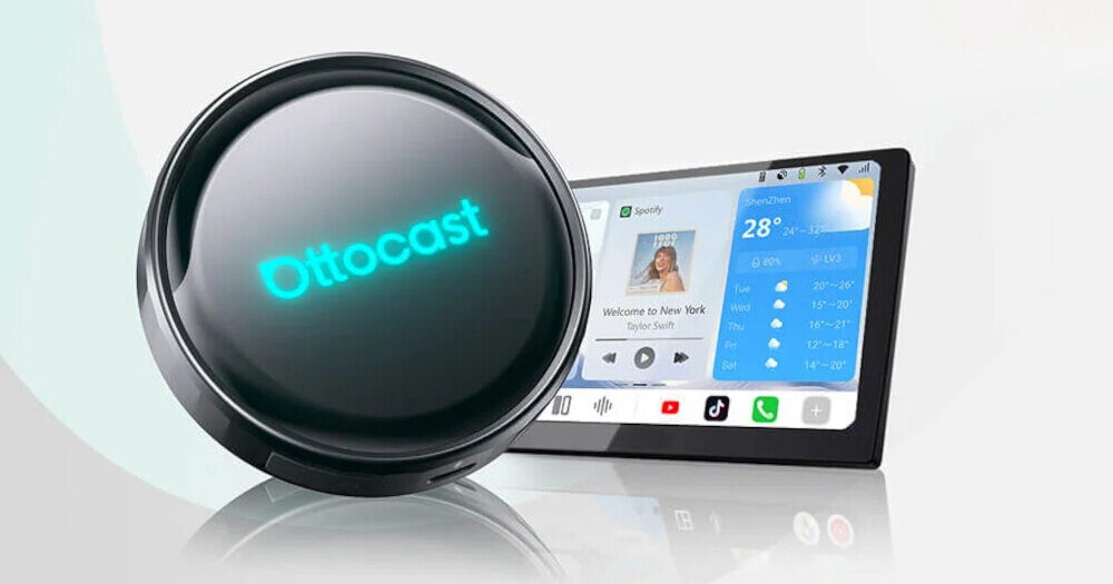 Na obrazie widoczny jest czarny, okrągły adapter z napisem \'Ottocast\'. W tle znajduje się ekran z interfejsem, na którym widać aplikację Spotify oraz prognozę pogody.