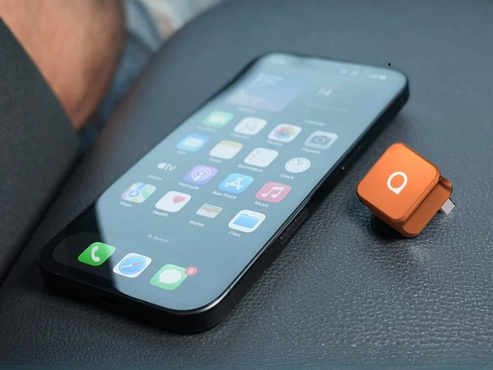 Adapter OTTOCAST CP88-T Mini Cube plug and play USB adapter przewodowy na bezprzewodowy CarPlay Android Auto bez aplikacji, adapter wraz z smartfonem leżący na podłokietniku auta